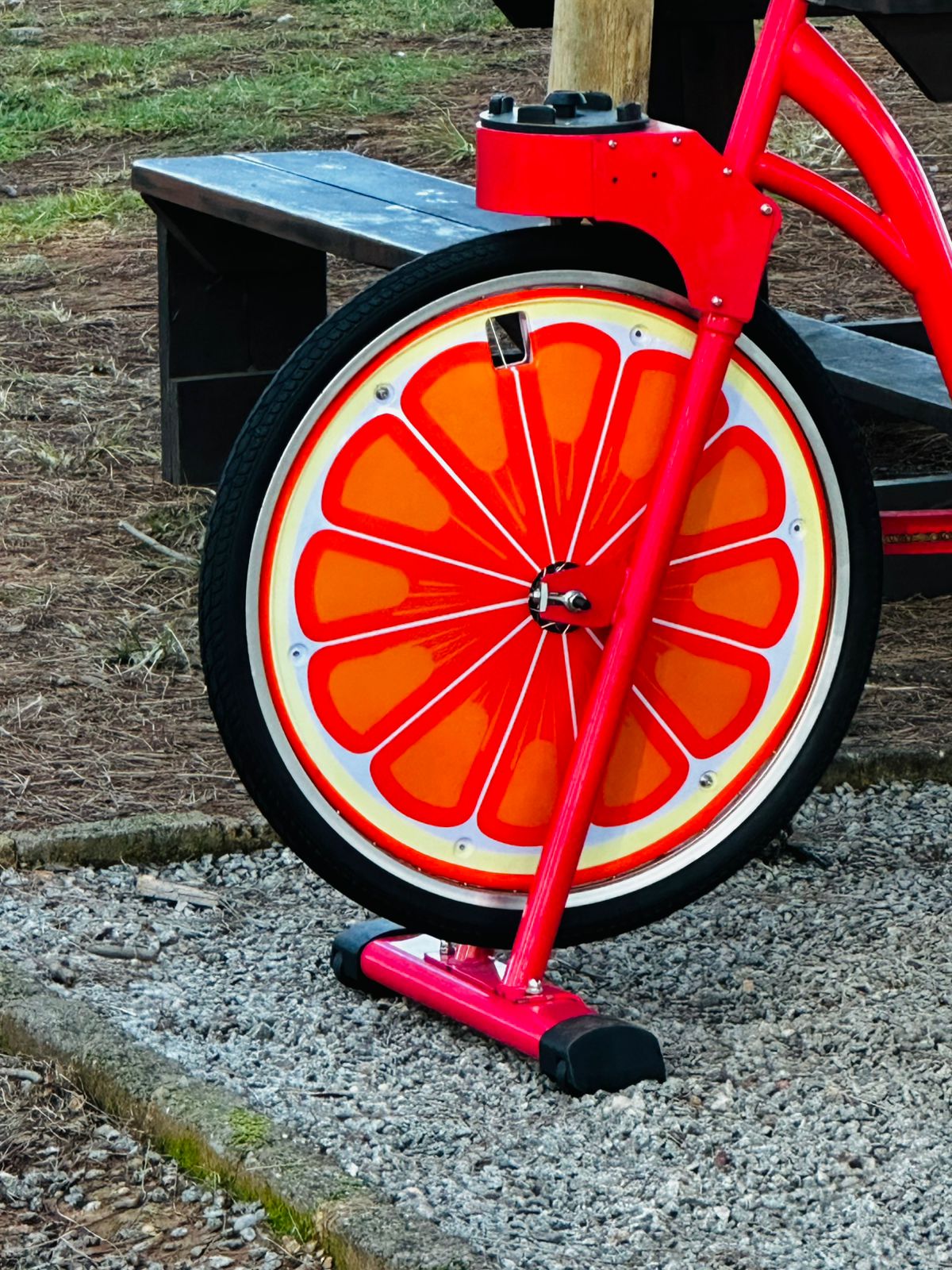 Close-up of a red smoothie bike with a bright orange-slice wheel